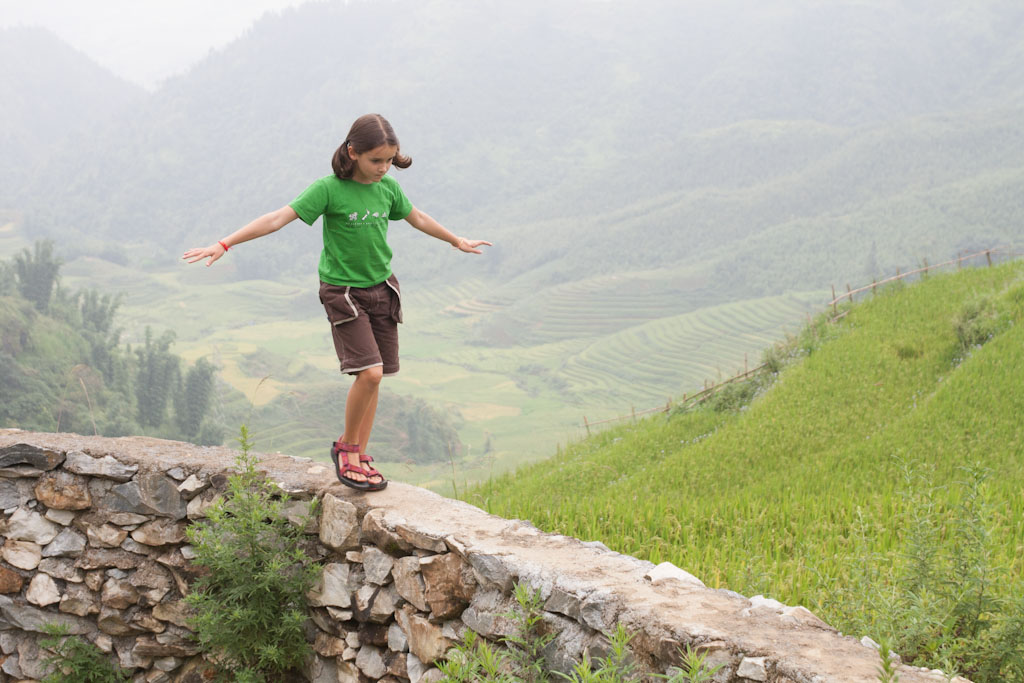 Reiseführer Vietnam Sapa Mädchen auf Mauer vor Reisfeldern